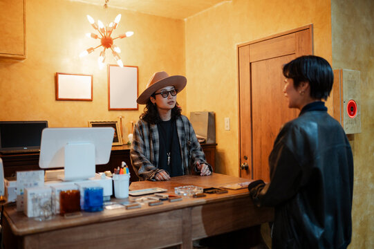 Stylish staff assisting customer at clothing store counter in Japan