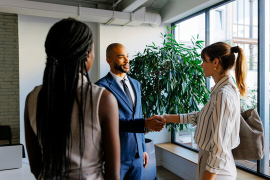Business partners shaking hands making deal in office