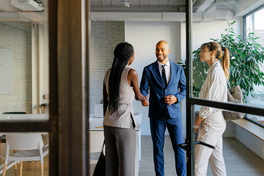 Business professionals shaking hands in office meeting