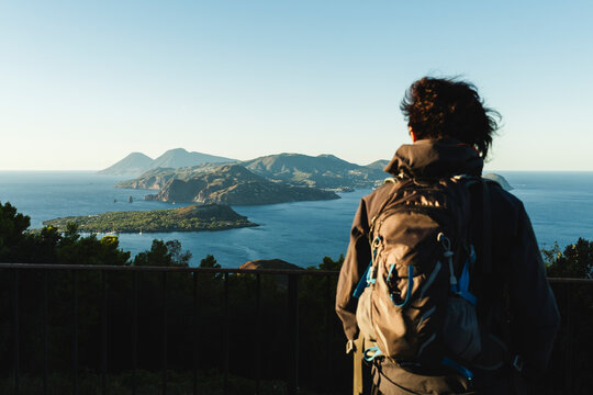 Hiker looking at the panorama of the Aeolian Islands at sunset