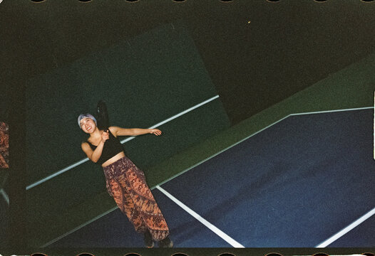 Woman playing pickle ball at night 