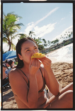 Woman eating fruit on the beach