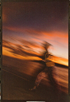 Blurry photo of woman running on the beach at sunset 
