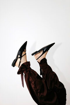 Woman's feet wearing black flats and satin pants