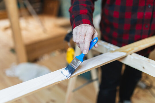DIY Project: Person Painting White on Wooden Surface