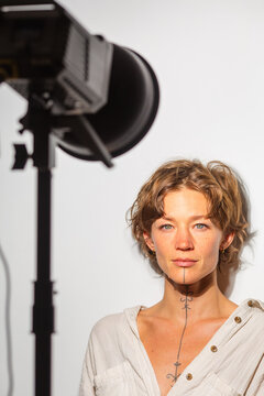 Woman standing under studio light facing camera