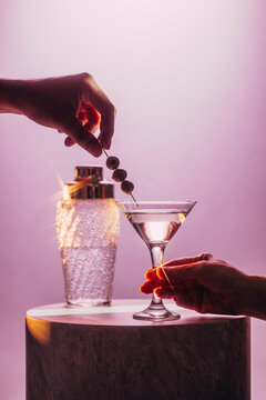 Elegant Martini Moment with Olives Against Soft Pink Cocktail Backdrop