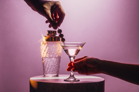 Elegant Martini Moment with Olives Against Soft Pink Cocktail Backdrop