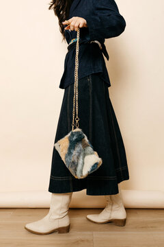 Woman holding stylish faux fur handbag