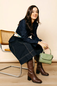 Woman wearing denim outfit with green bag