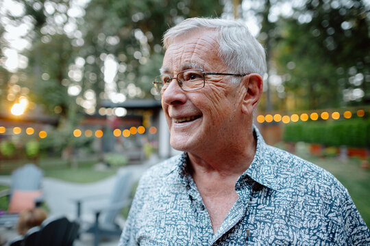 Candid portrait of smiling elderly man at outdoor gathering