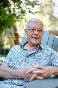 Candid portrait of a smiling elderly man enjoying sunny outdoors