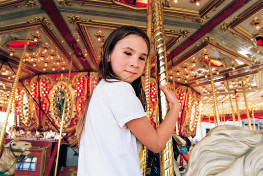 Portrait of child riding a carousel horse at the fair