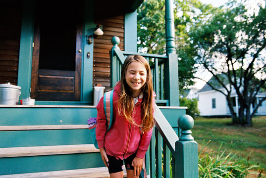 Smiling laughing girl with backpack on first day of school