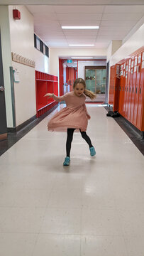 Girl Spinning in School Hallway
