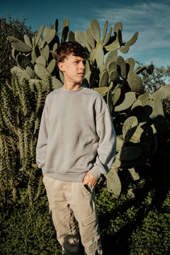 Young boy standing outdoors with cactus plants