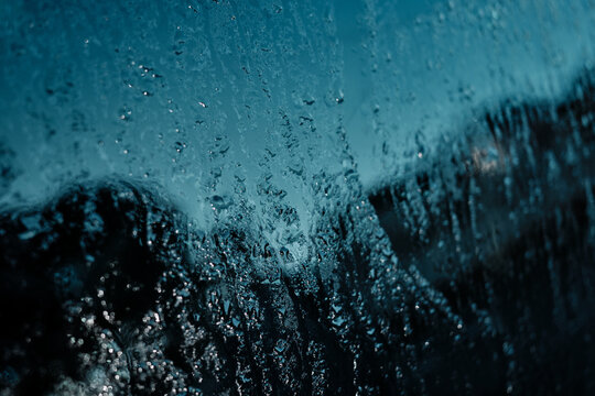 Water drops flowing on glass creating abstract pattern