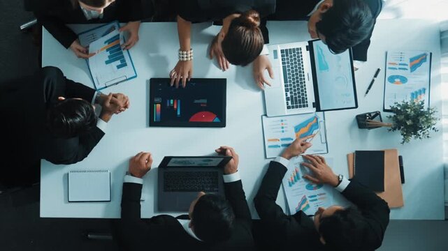 Top view of smart business people brainstorm marketing idea at meeting table while compare stock market investment data between laptop and tablet. Business team planning financial plan. Directorate.