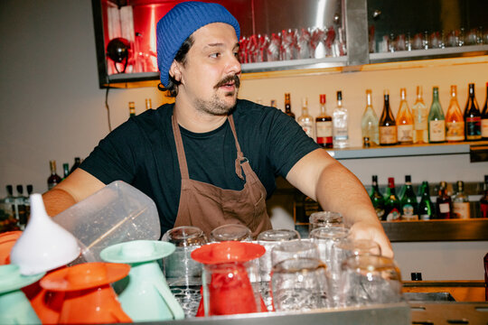 Bartender Organizing Clean Glasses
