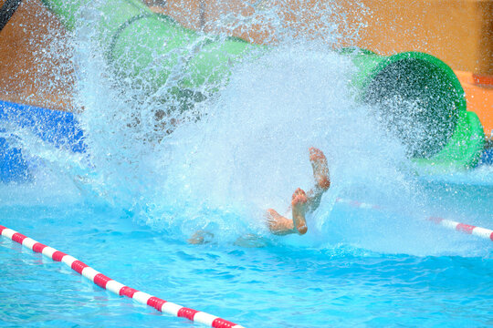 Child splashing water exiting fast water slide
