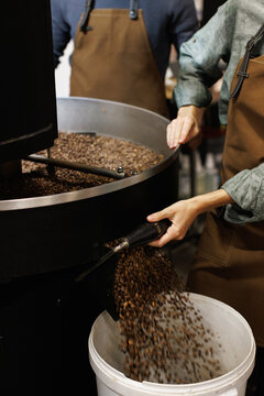 Partial worker controlling of coffee beans falling out in bucket