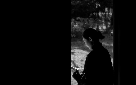 Silhouette of a Female Reader in Light and Shadow (Black and White).