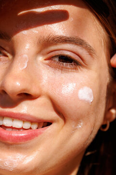 Smiling Woman With Face Cream in Sunlight Skincare 