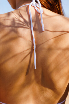 Close-Up of Woman&rsquo;s Back in Summer Sunlight With Shadows and Swimwear