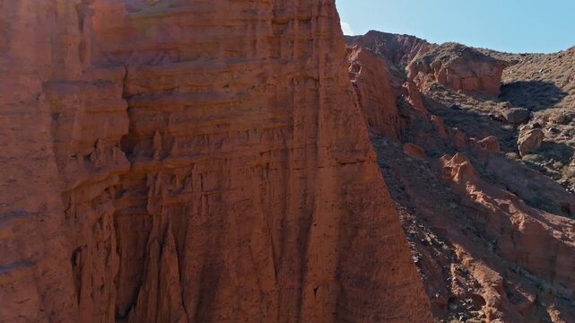 Majestic eolian sandstone cliffs in arid desert badlands of Kyrgyzstan, reveal drone shot