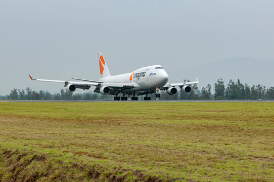 An impressive Magma Airlines Boeing 747 cargo plane lands on the runway at Mariscal Sucre Airport in Quito on a cloudy day.