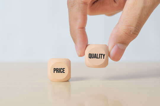 Hand choosing quality over price using wooden cubes. Concept of customer preference, value perception, product excellence, business strategy and smart purchasing decision.