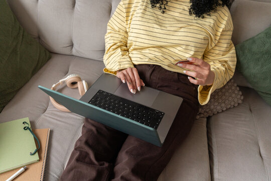 Woman relaxing with a laptop and headphones at home