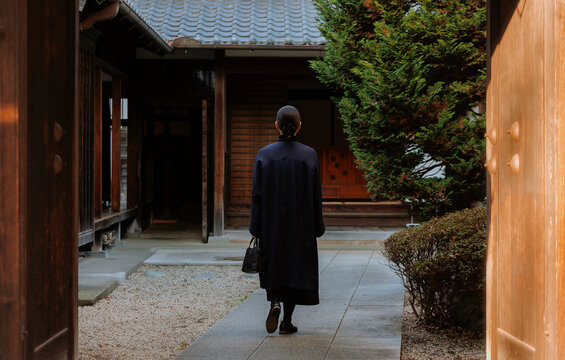 Back View of a Woman Entering a Traditional Japanese Garden.
