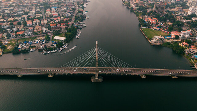 Aerial view of the Lekki-Ikoyi Link Bridge cutting through the dark waters, framed by the city's buildings, Lagos, Lagos, Nigeria.