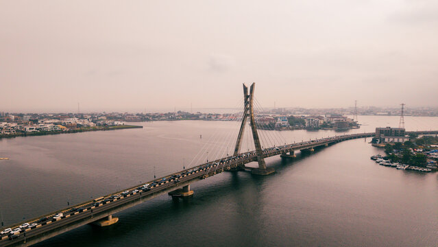 Aerial view of Lekki-Ikoyi Link Bridge cutting through the dark waters, a vital artery pulsating with life amidst the coastal city, Lagos, Nigeria.
