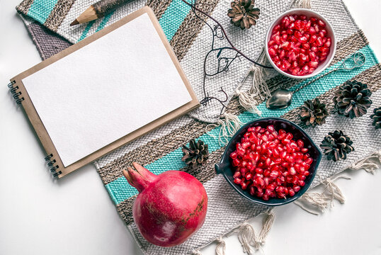 Pomegranate and notebook on textured textile cover