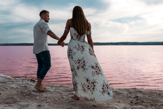 Couple enjoying a scenic walk by the pink lake