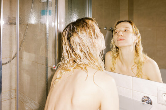 Woman in Bathroom Reflecting in Mirror After Showering