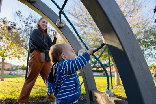 Mother watching toddler playing at playground