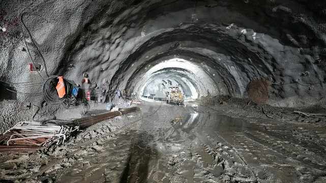 Tunnel construction site with muddy ground and equipment