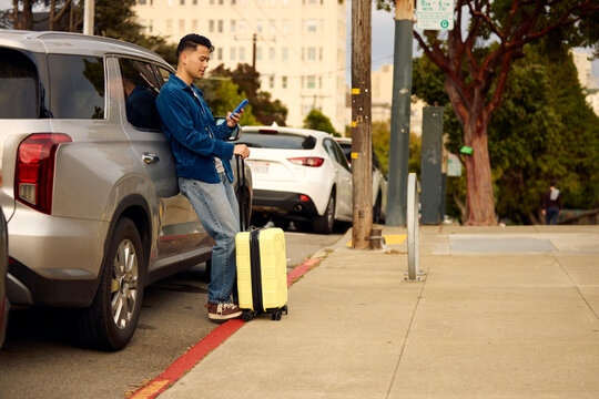 Handsome man leans against his car