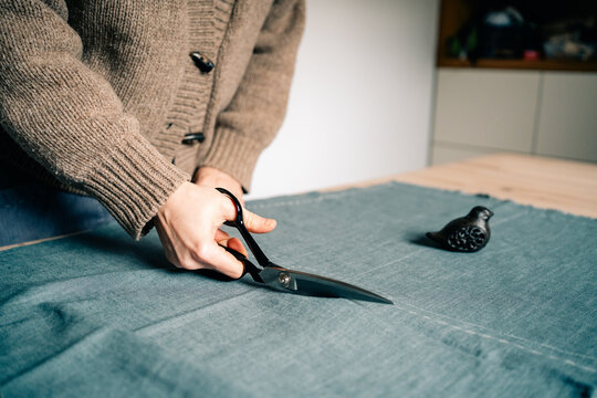 Cutting Fabric With Scissors for Sewing Project in Home Studio