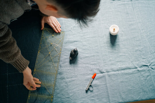 Sewing Expert Crafts Clothing With Fabric and Tools in a Cozy Space