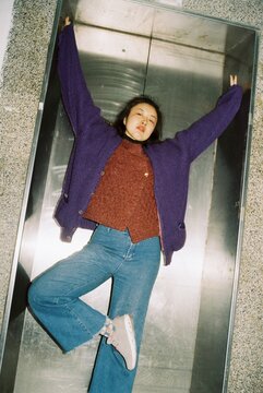 Asian woman posing in front of an elevator