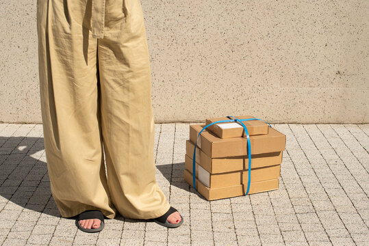 Person standing by boxes on sunny day outdoors