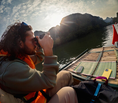 Traveler using a camera while exploring river landscape