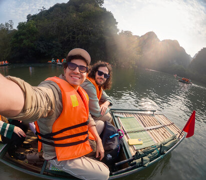 Two travelers taking sunset selfie on river boat