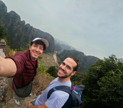 Two travelers posing on elevated trail overlooking valley