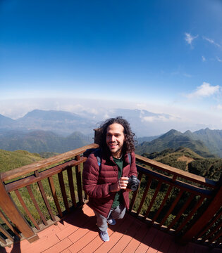 Traveler standing on wooden deck overlooking mountains