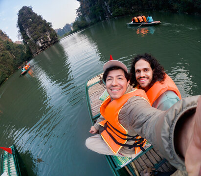 Two travelers taking selfie on boat in scenic river area